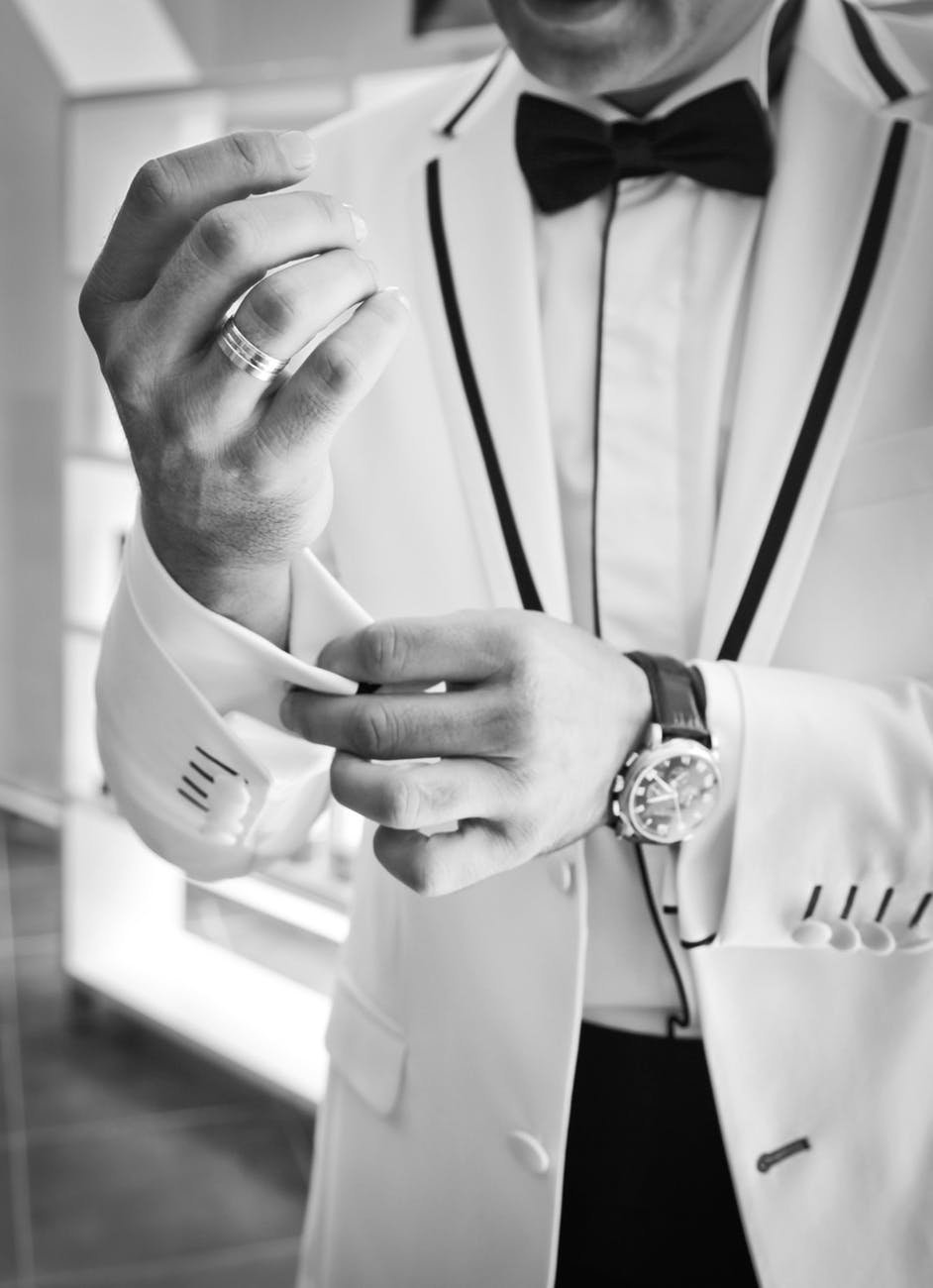man wearing tuxedo in grayscale photography
